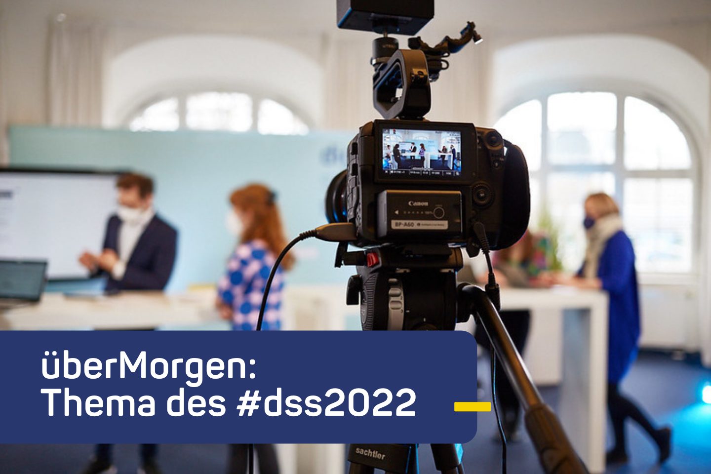 Im Vordergrund das Display einer Kamera, im Hintergrund eine Studioszene des Digital Social Summit 2021 in Hamburg.