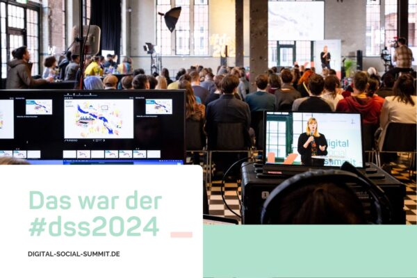 Das war der #dss2024 Zu sehen ist die Konferenz vom Technikdesk aus. Man sieht Monitore und dann das Publikum, das zur Speakerin auf der Bühne blickt.